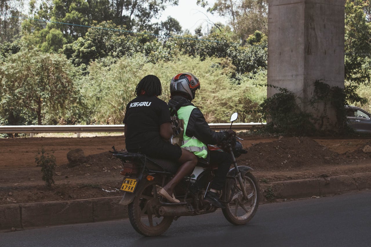 Two people on a motorbike in Nairobi, Kenya, showcasing urban transport.